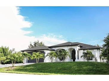 Modern home with two-car garage and manicured lawn at 11061 Sandrift Ave, Englewood, FL 34224