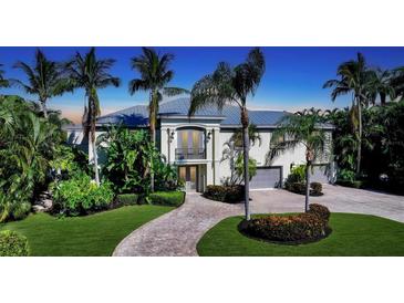 Two-story home with a metal roof, double door entry, and lush landscaping at 549 Sloop Ln, Longboat Key, FL 34228