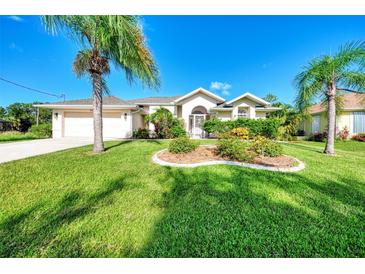 Landscaped front yard with lush grass and palm trees at 139 Long Meadow Lane Ln, Rotonda West, FL 33947