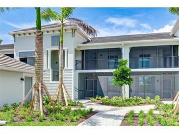 Beautiful two-story condo featuring screened lanais, well-maintained landscaping, and paver walkways at 17445 Opal Sand Dr # 104, Venice, FL 34293