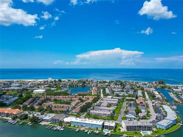 Aerial view of coastal community, with ocean, buildings, and waterways at 12405 3Rd E St # 206, Treasure Island, FL 33706