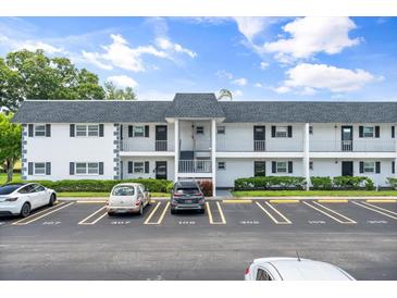 Exterior view of a two-story condominium building with parking lot in front at 304 47Th Avenue W Dr # 307, Bradenton, FL 34207