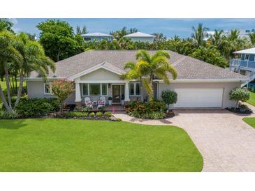 Single-Gathering home with a manicured lawn and landscaping at 111 49Th St, Holmes Beach, FL 34217