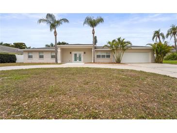 Charming single-story home featuring a well-manicured lawn, circular driveway, and a two-car garage at 2232 River Ridge Dr, Sarasota, FL 34239