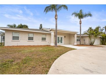 Charming single-story home with stucco and stone accents, palm trees, and a circular driveway at 2232 River Ridge Dr, Sarasota, FL 34239