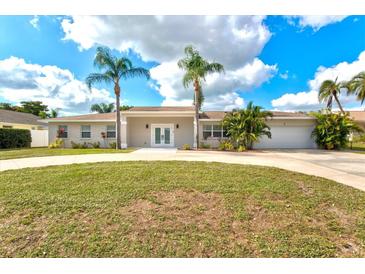 Charming home with a circular driveway, fresh lawn, and well-maintained landscaping at 2232 River Ridge Dr, Sarasota, FL 34239