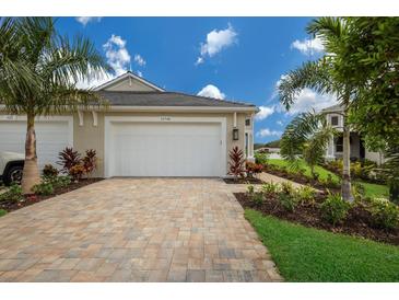 Two-car garage with paver driveway and tropical landscaping at 10748 Klee Ave, Bradenton, FL 34212
