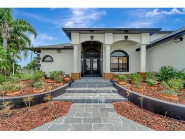 Elegant front entry with a stone walkway and landscaping at 12307 S Access Rd, Port Charlotte, FL 33981