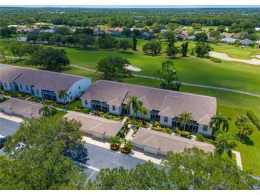 Stunning aerial view of condo community overlooking lush green golf course with mature trees and tropical landscaping at 6904 Drewrys Blf # 803, Bradenton, FL 34203