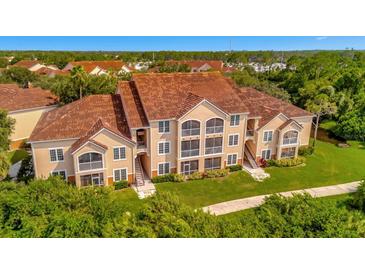 Aerial view of a two-story building with Spanish tile roofing in a lush setting at 4126 Central Sarasota Pkwy # 2026, Sarasota, FL 34238