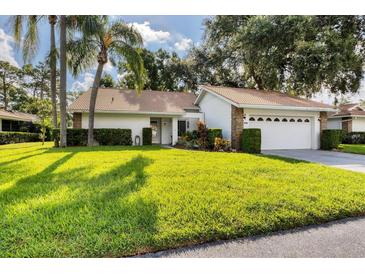 Single story home with a well maintained lawn at 5611 Garden Lakes Majestic, Bradenton, FL 34203