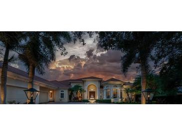 Luxury home exterior at dusk with fountain and landscaping at 3218 Signet Ct, Sarasota, FL 34240