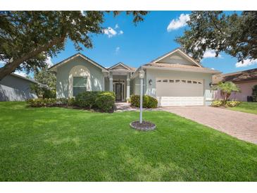 A charming one-story house with light blue siding, a white garage door and lush green lawn at 7316 43Rd E St, Sarasota, FL 34243