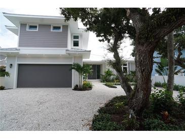 Modern two-story home with gray siding, white trim, and a gravel driveway at 4819 Higel Rd, Sarasota, FL 34242