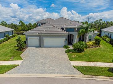 Two-story house with three-car garage and paver driveway at 12444 Destin Loop, Venice, FL 34293