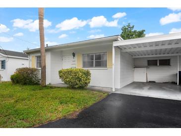 White single story home with carport and landscaping at 6041 Arlene Way, Bradenton, FL 34207