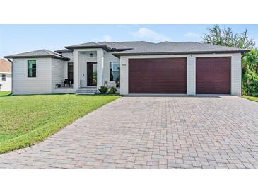 Beautiful home exterior with a two-car garage and a brick paver driveway at 8104 Bosco Rd, Port Charlotte, FL 33981