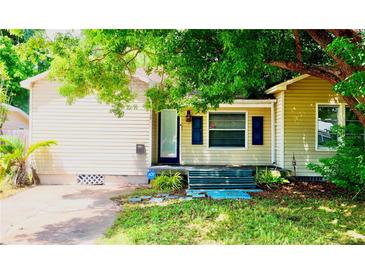 Charming single-story home with light yellow siding, an ADT security system, and a lush tree-lined front yard at 5415 5Th N Ave, St Petersburg, FL 33710