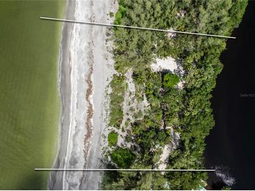 Aerial view of waterfront property with beach access and lush landscaping at 8440 Sanderling Rd, Sarasota, FL 34242