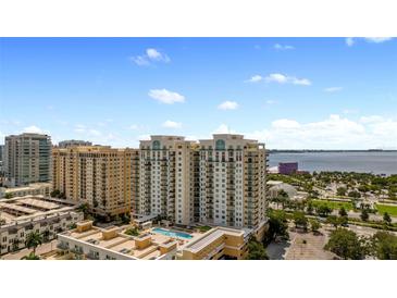 Aerial view of a luxury condo building with pool and waterfront views at 800 N Tamiami Trl # 402, Sarasota, FL 34236