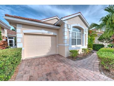 House exterior showcasing a tan color scheme, and brick paver driveway at 7823 33Rd E St # 20, Sarasota, FL 34243