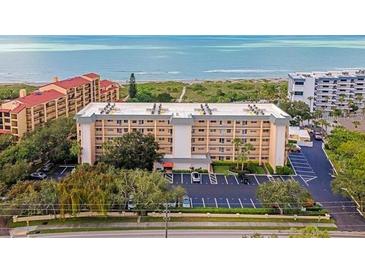 Oceanfront condo building with parking and lush landscaping at 8630 Midnight Pass Rd # 103A, Sarasota, FL 34242