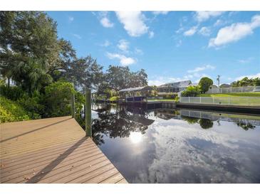 Scenic canal view from a private dock, reflecting the sky and surrounding trees at 4532 Shark Dr, Bradenton, FL 34208