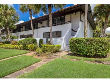 Two-story condo building with lush landscaping at 3500 El Conquistador Pkwy # 238, Bradenton, FL 34210