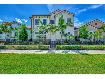 Beautiful two-story house with lush landscaping and gated entrance at 906 E Venice Ave, Venice, FL 34285