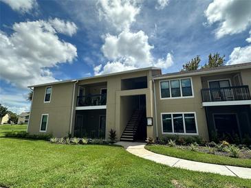 Two-story building with light beige exterior, balconies, and landscaping at 4025 Crockers Lake Blvd # 11, Sarasota, FL 34238