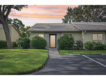 Exterior view of a condo unit with a landscaped yard and parking at 2708 60Th Avenue W Ter # A, Bradenton, FL 34207