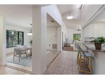 Open-concept interior view showcasing the dining area, hallway, and kitchen with bright, natural light at 3601 Quail Hollow Ln, Bradenton, FL 34210