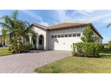 One-story home with a tile roof, white garage door, and landscaped yard at 1922 6Th St E, Palmetto, FL 34221
