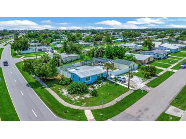 Aerial view of a light blue home with a pool and detached guest house, located on a corner lot at 21403 Glendale Ave, Port Charlotte, FL 33952