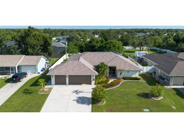 Single-Gathering home with a three-car garage and landscaped yard at 10268 Alexandria Ave, Englewood, FL 34224