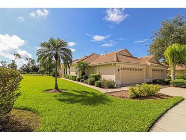 House exterior with a two-car garage and lush landscaping at 5107 Whispering Oaks Dr, North Port, FL 34287