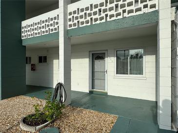 Exterior view of building, showing a light-colored building with green accents and a walkway at 5850 Welcome Rd # J6, Bradenton, FL 34207