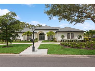 Large home with a circular driveway and lush landscaping at 3973 Boca Pointe Dr, Sarasota, FL 34238