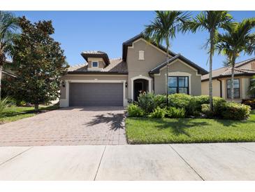 Two-story house with gray garage door and landscaping at 5828 Pomarine Ct, Sarasota, FL 34238