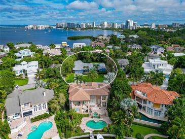 Stunning aerial view of property showcasing a home, lush landscaping and waterfront views in the background at 1389 Harbor Dr, Sarasota, FL 34239