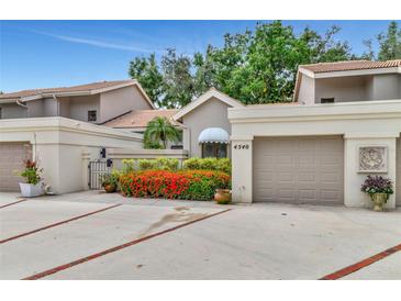 Condo home with attached garage and red flowers at 4540 Ascot N Cir, Sarasota, FL 34235