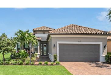 Single-story home with gray exterior, two-car garage, and landscaped yard at 4507 Terrazza Ct, Bradenton, FL 34211