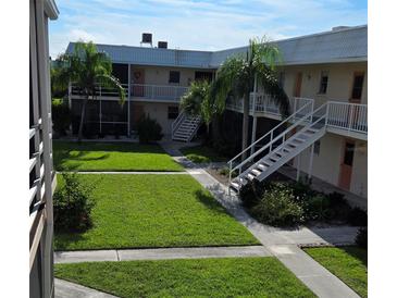 Exterior view of an apartment building with a grassy courtyard at 400 Base E Ave # 229, Venice, FL 34285