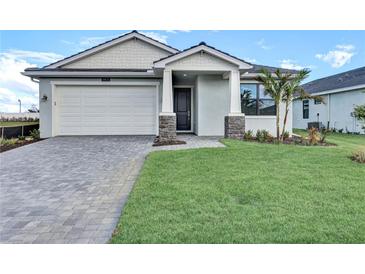One-story home with white garage door and landscaping at 18876 Daybreak Dr, Venice, FL 34293
