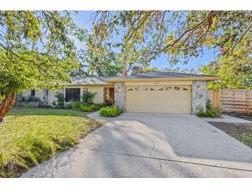 Charming home featuring a stone facade, mature trees, and a well-manicured lawn at 7607 9Th Avenue Nw Dr, Bradenton, FL 34209