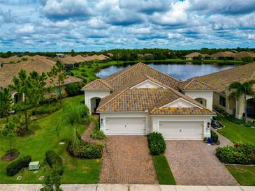 Two-story house with two-car garage, landscaped yard at 11624 Okaloosa Dr, Venice, FL 34293