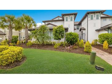Two-story home with lush landscaping and brick driveway at 7390 Divot Loop, Lakewood Ranch, FL 34202