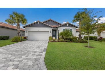 Charming house exterior with a gray and white color scheme, and a nicely landscaped lawn at 3822 Savanna Palms Ct, Bradenton, FL 34211