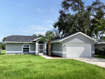 Newly constructed home with gray exterior, a two-car garage, and a well-manicured lawn at 5278 Sabrina Ter, North Port, FL 34286