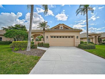 Charming single-story home with a two-car garage, tiled roof, and lush landscaping at 7157 Del Lago Dr, Sarasota, FL 34238